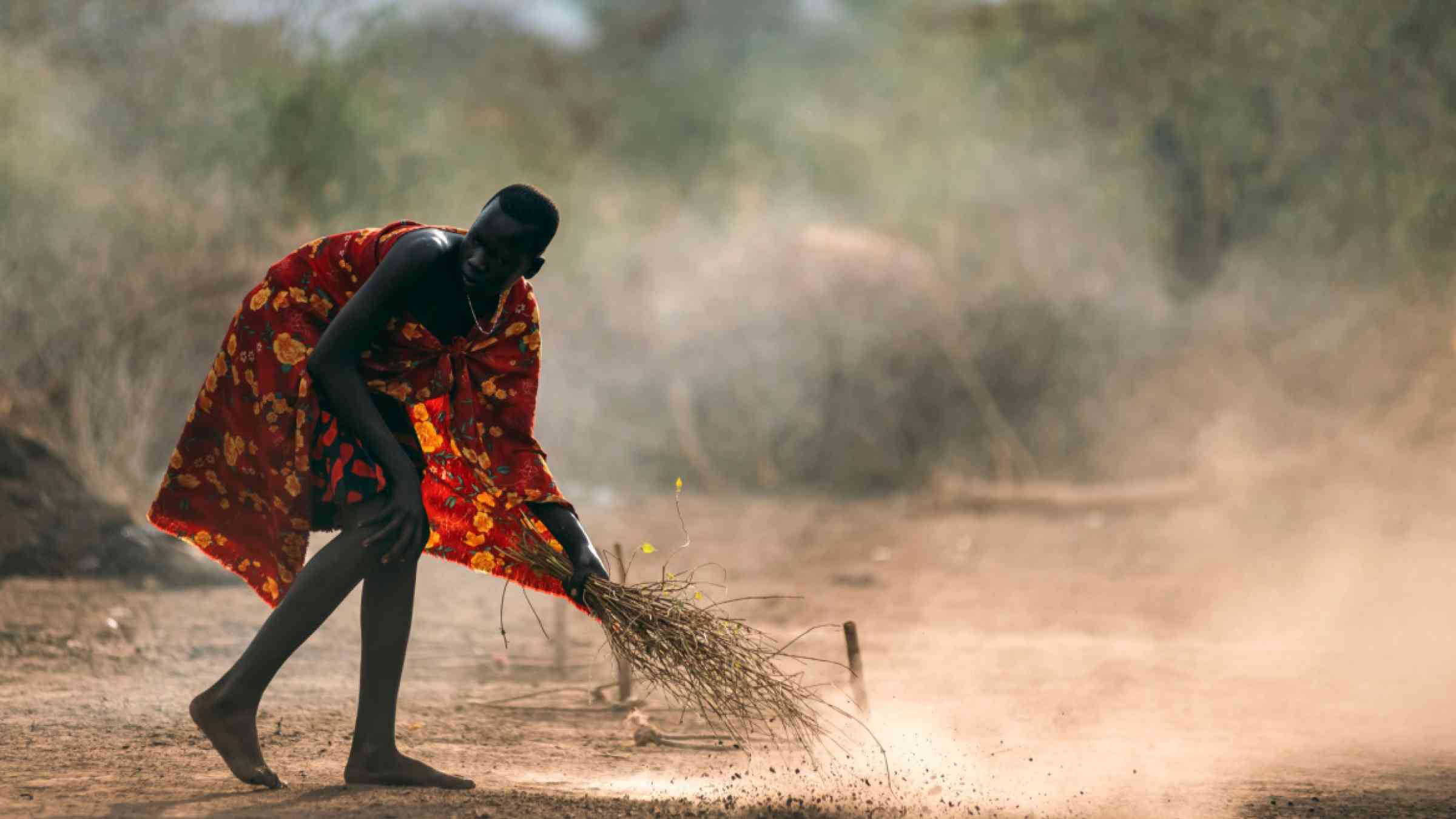 South Sudan man sweeping dry streets