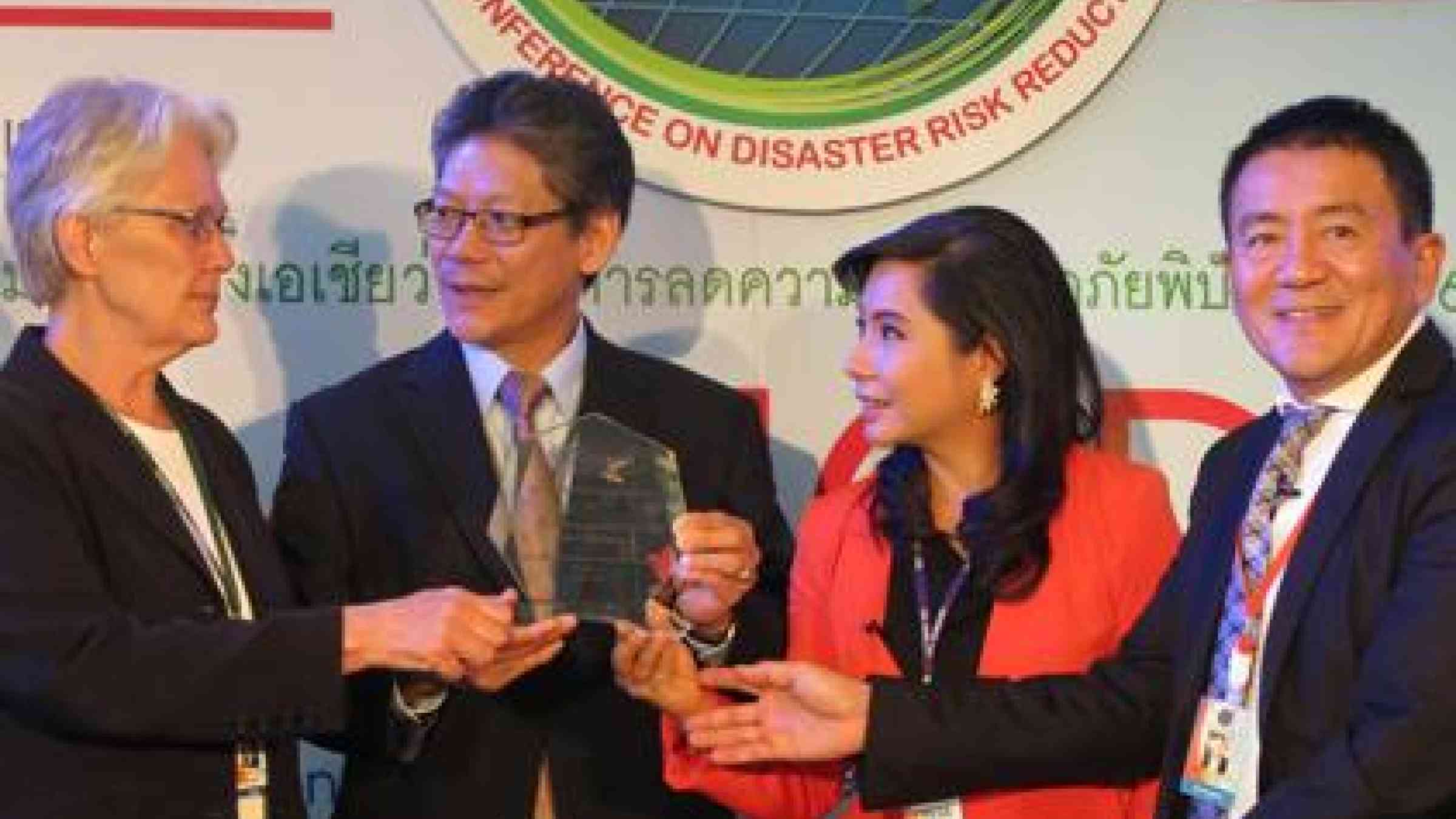 Director of Thai PBS Mr Somchai Suwanban (second left) receives the award from Ms Margareta Wahlström (left), with Ms Darin Klong-ugkara and Dr Seree Supratid joining the presentation. (Photo: UNISDR)