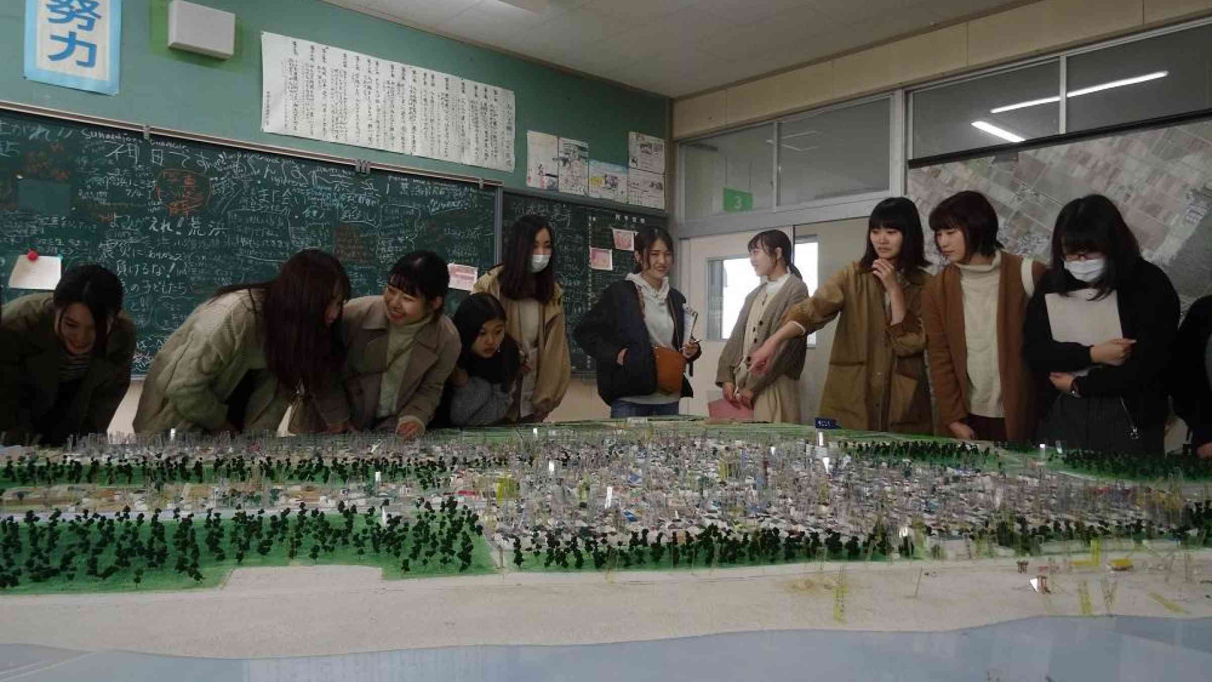 Student teachers visiting the exhibition space at Arahama Elementary School in Sendai, Japan, for World Tsunami Awareness Day