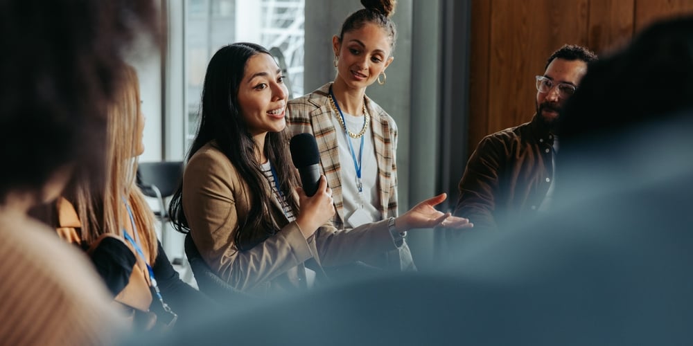 engaging in a debate with peers during a group meeting