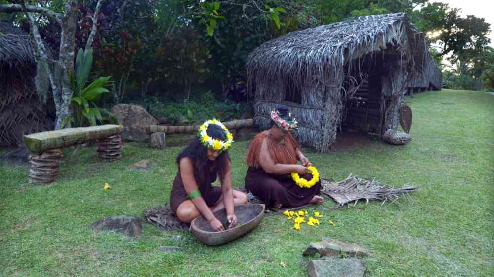 Two indigenous women work outdoors 