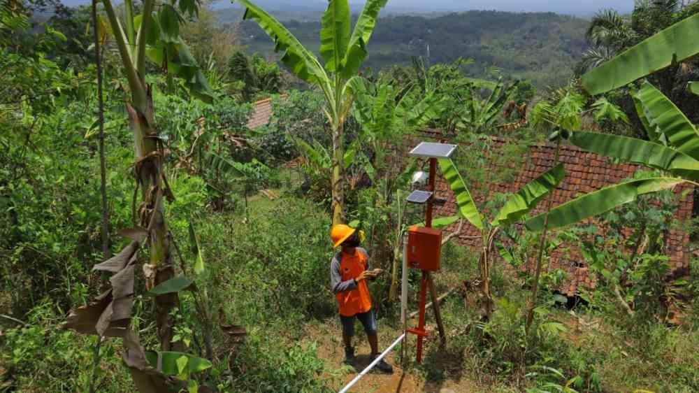 officer checking the condition of the solar panel, early warning system, in anticipation of landslides