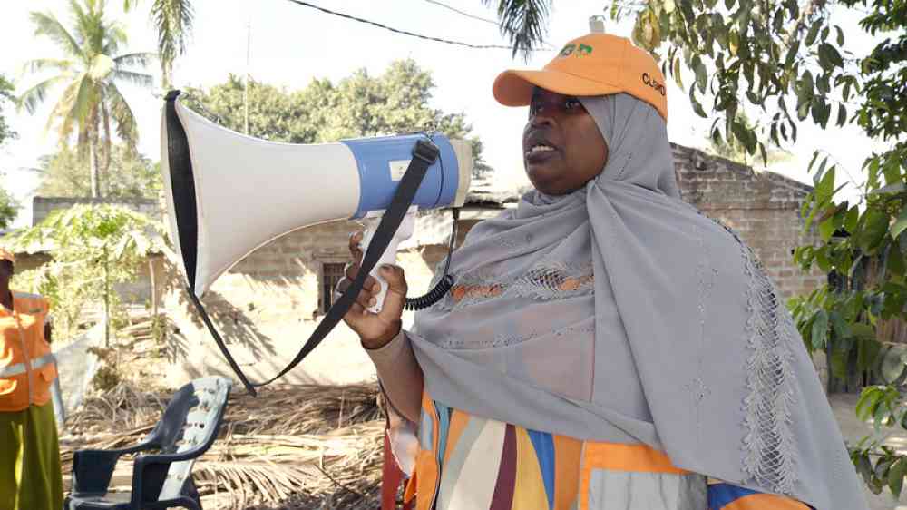 A local disaster risk reduction committee member in Mocuba District uses a megaphone to communicate early warning information during a simulation exercise