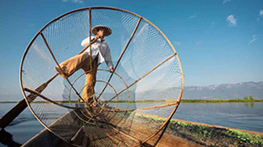 fisherman with net in a small boat