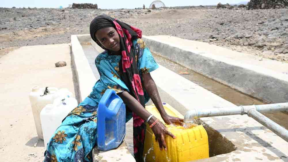 15-year-old Amna collects water at a distribution point in Wadsharefey refugee camp in Kassala state.