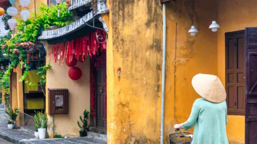 Hoi An, Vietnam - April 16th, 2024: Scenic morning of trafic, decorated silk lanterns, amazing traditional old yellow houses. The historic old town of Hoi An is UNESCO World Heritage Site since 1999.