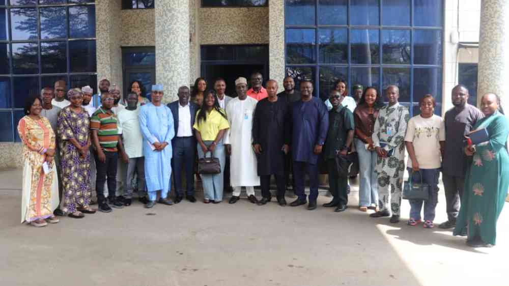 A group photo taken during the Liberia-Nigeria study tour, people are stood in two rows in front of a building