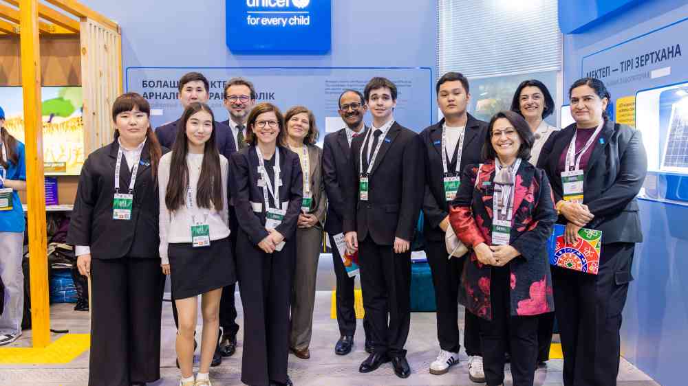 Group of participants and representatives of the UNDRR, UNICEF, Youth Representatives are standing at the UNICEF Pavilion booth