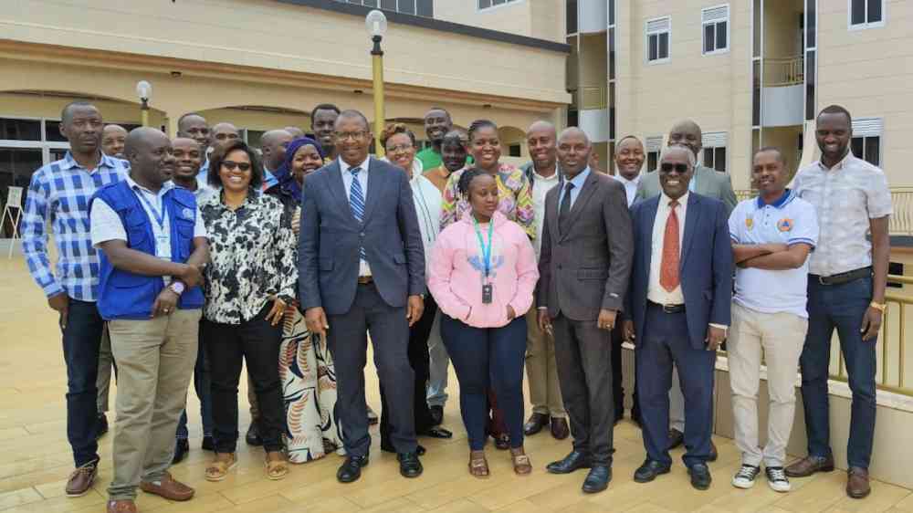 A group photo taken at the Burundi SFM workshop in February 2026: people are stood outside in three rows in front of a building complex, many of them are smiling