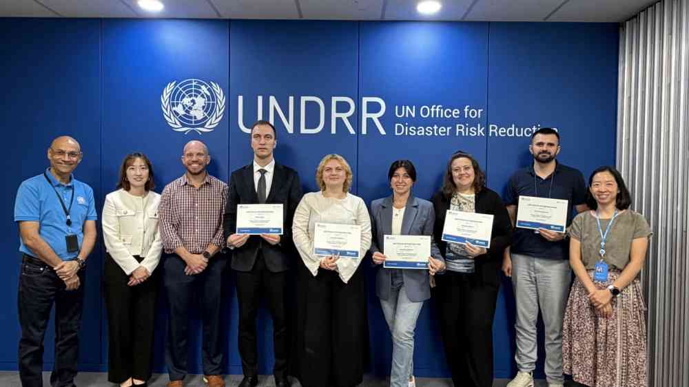 Ukrainian participants holding the certificates with the facilitators at the UNDRR office
