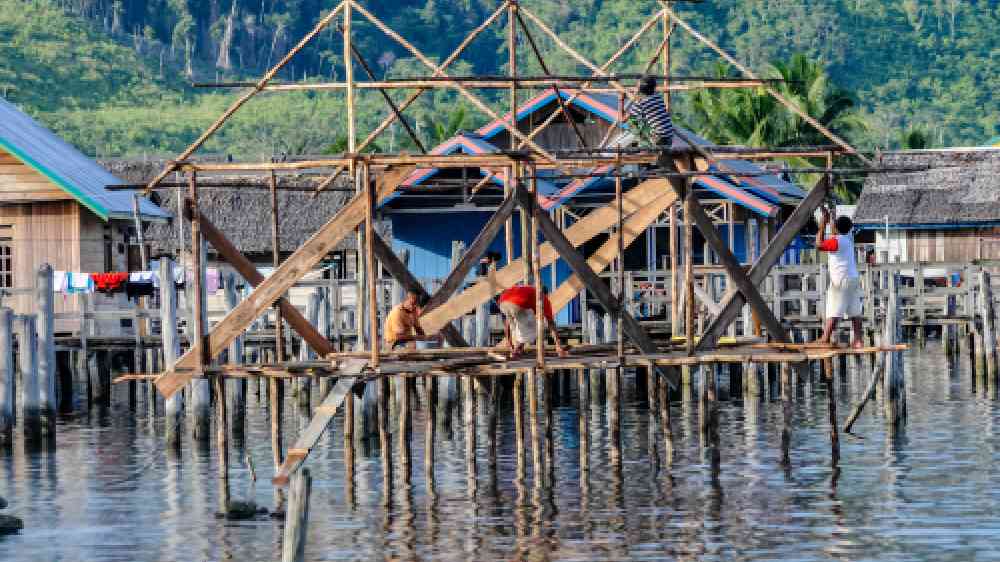 KOLONODALE, CENTRAL SULAWESI - OCT 23,2009: a group of workers is building a new stilt house in Kolonodale on October 23, 2009