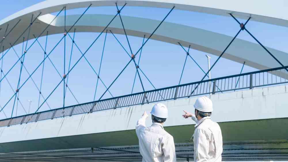 Two engineers inspecting a bridge as part of an infrastructure resilience assessment