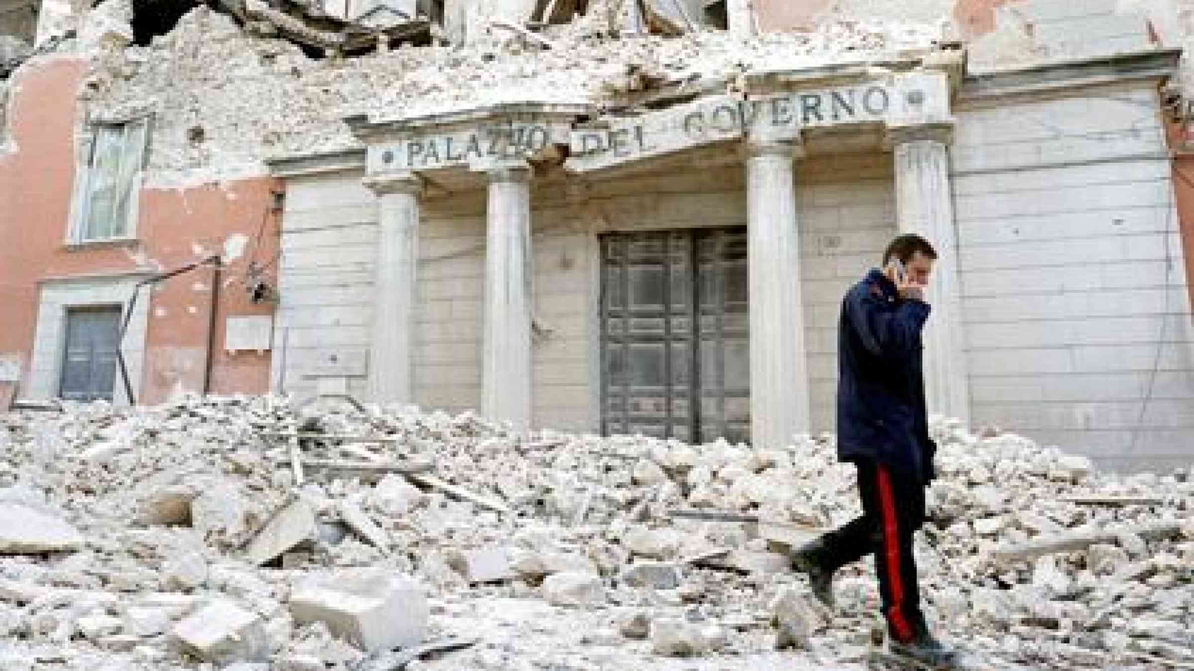 An Italian military carabinieri walks on debris past destroyed buildings after an earthquake, in downtown Aquila April 6, 2009. (REUTERS/Alessandro Bianchi)