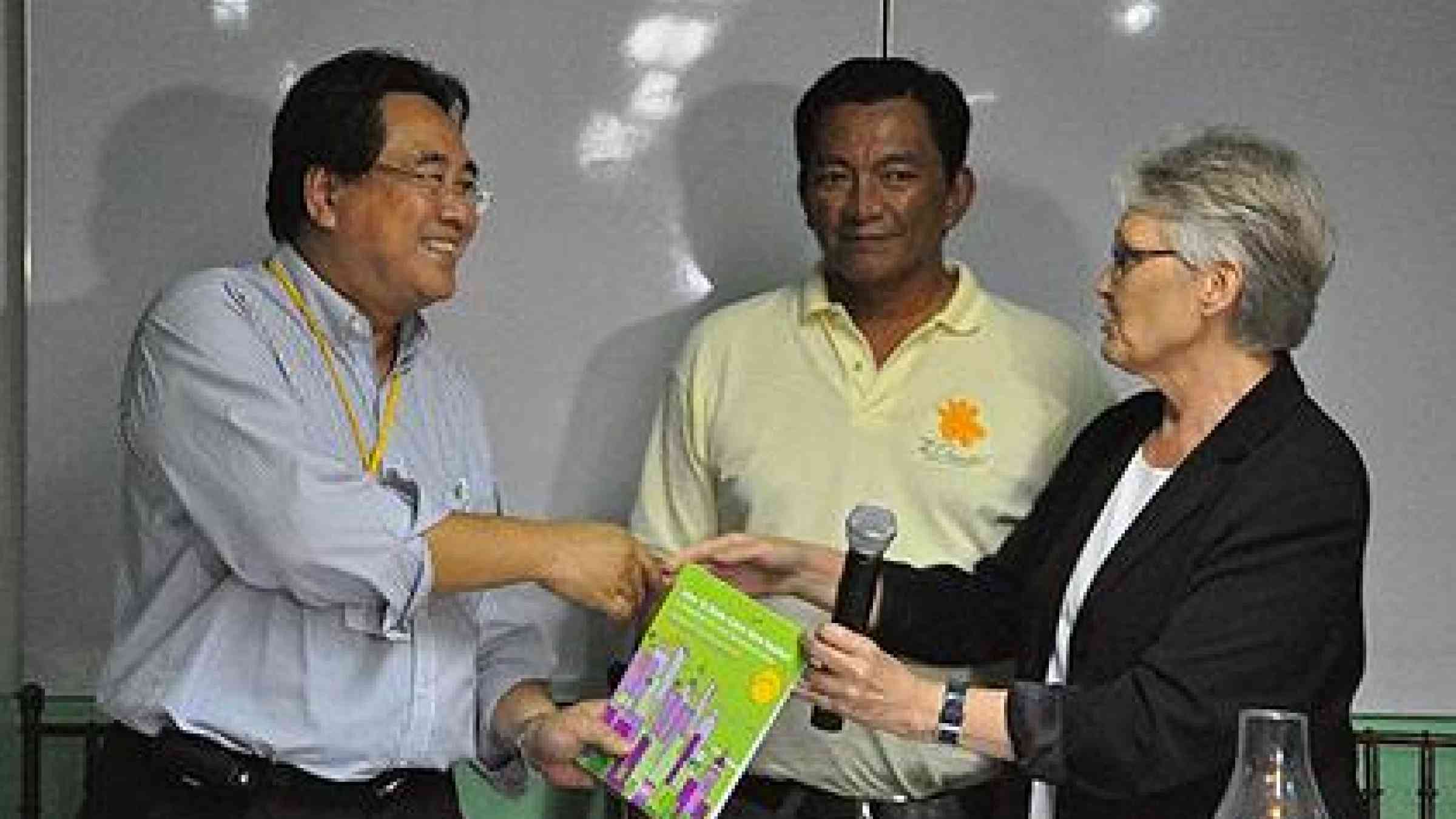 Photo of Margareta Wahlström, UN Secretary-General’s Special Representative for Disaster Risk Reduction (right) with Albay Governor Joey Salceda (centre)  presenting a copy of the 'How to make cities more resilient: a handbook for local government leaders' to Congressman Rufus Rodriguez of the second district of Cagayan de Oro (left).