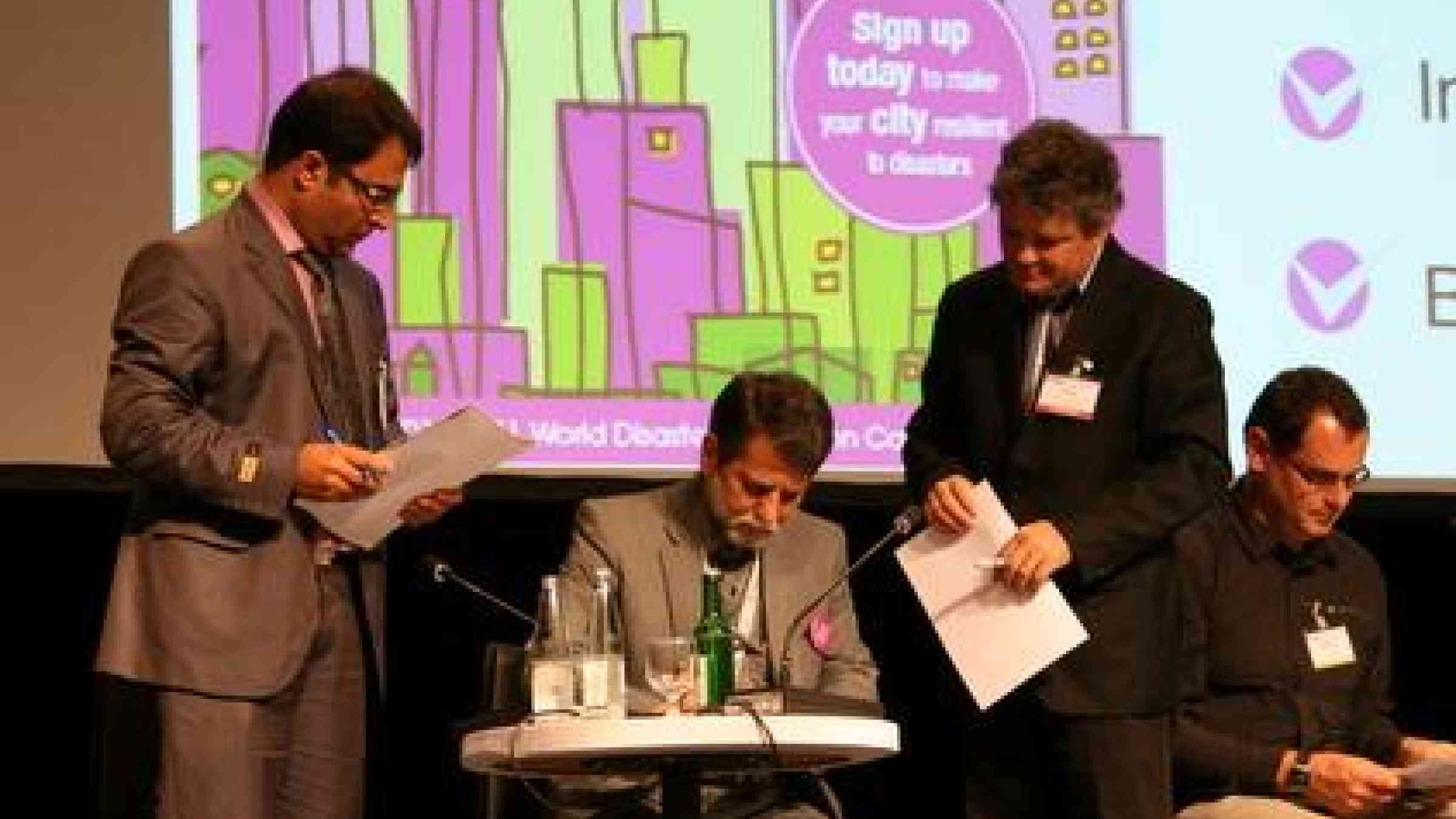 Abholghassem Baghbannezhad (centre), Director of the Iranian Crisis Management Organization, Municipality of Mashhad signs a commitment to the Ten Essential of the Making Cities Resilient campaign.