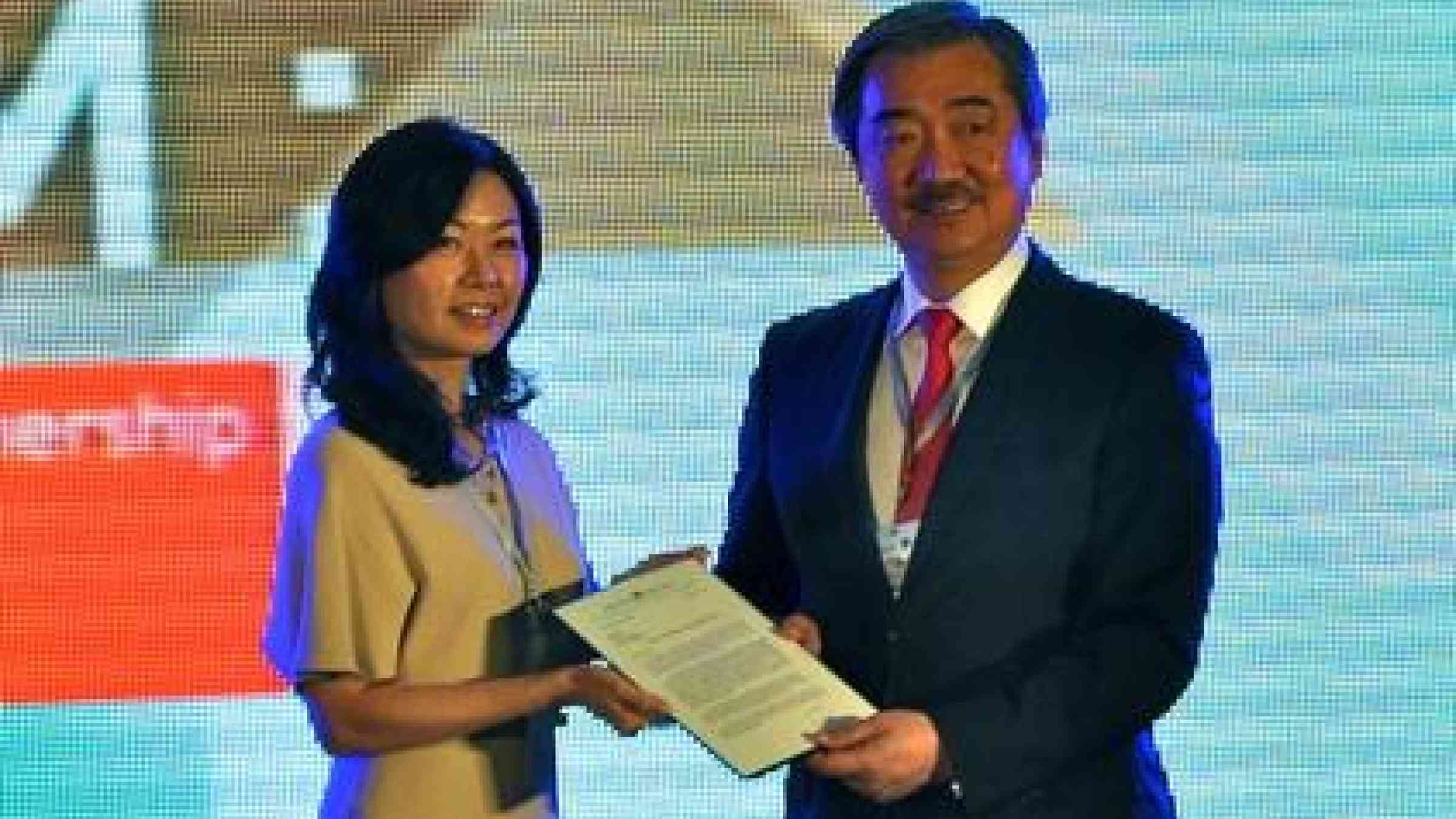 Hans Sy (right), President of SM Prime Holdings, receives an invitation by UNISDR Private Sector Advisory Group (PSAG) member Sandra Wu, President and CEO of Kokusai Kogyo Holdings, to join the PSAG. (Photo / Emmanuel M. de Guzman)