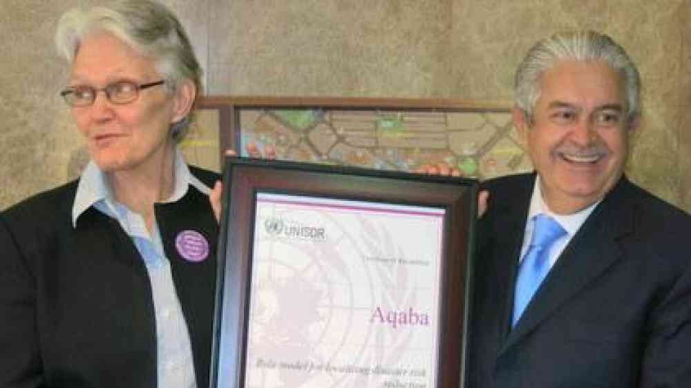 From left: UNISDR Chief, Margareta Wahlstrom, and Aqaba Chief Commissioner, Dr. Kamel Mahadin, share a light-hearted moment as he accepts certification of the city's role model status in the Making Cities Resilient Campaign.