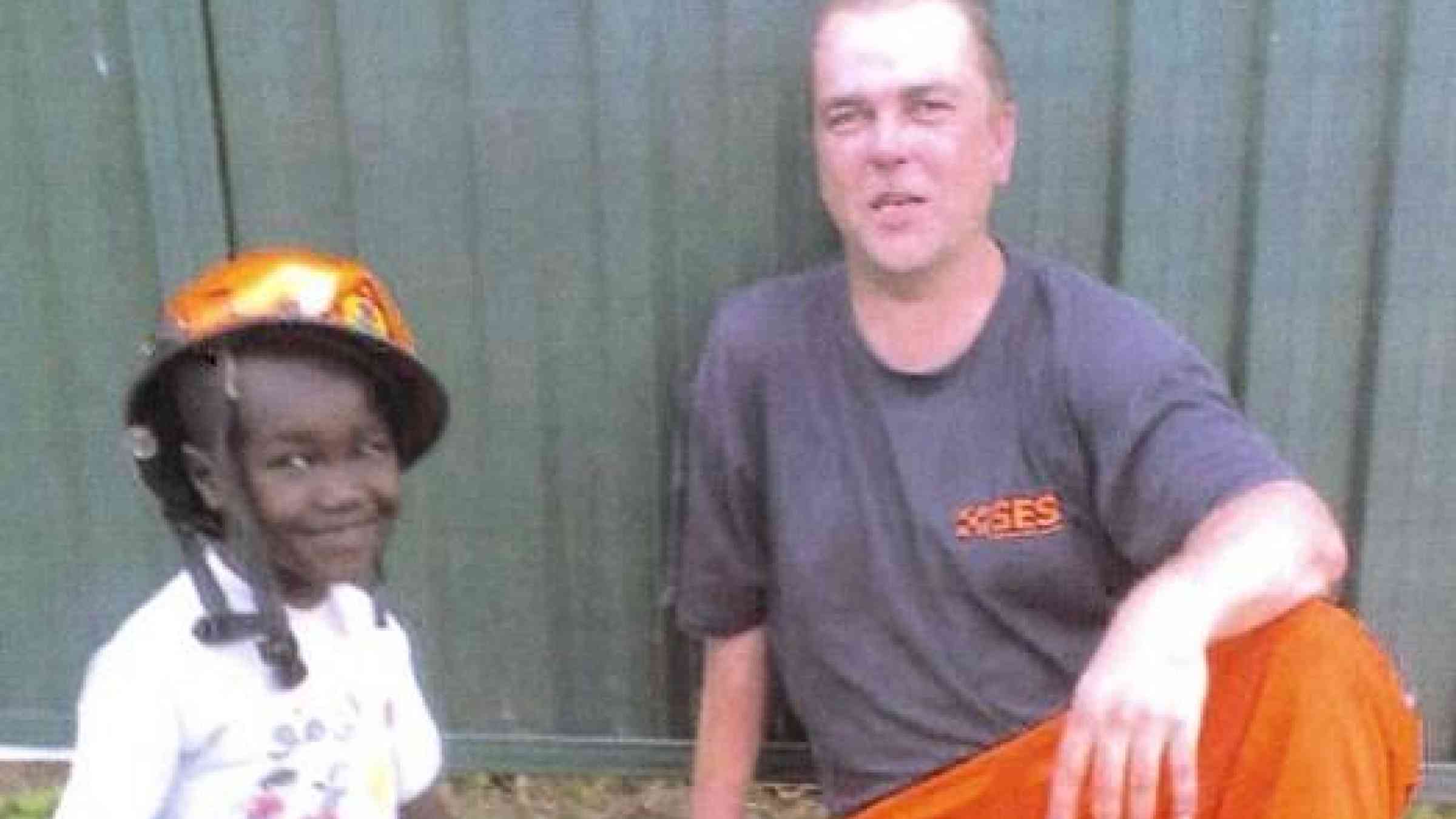 <b>Exhausted and sweaty: </b>Stuart Mawbey makes friends with a boy from a refugee family in west Sydney, who he describes as ‘a little charmer’,  after patching up the roof of their house in the wake of violent storms.