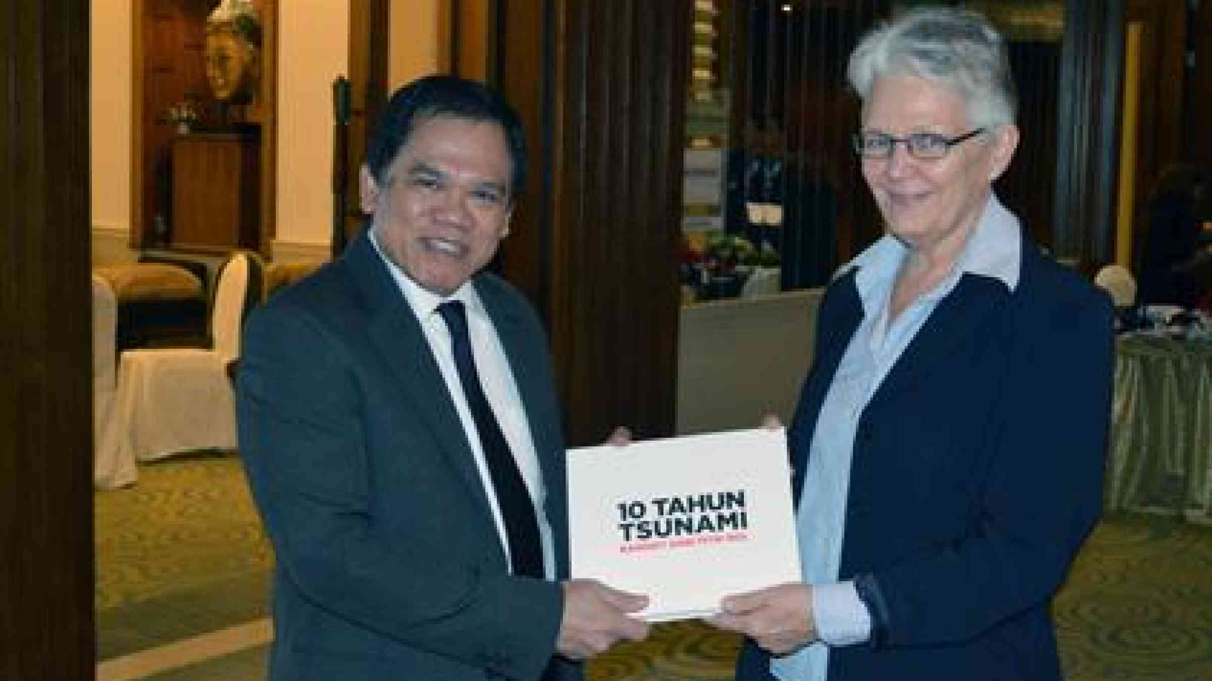 UNISDR Chief Margareta Wahlström receives a book on the 2004 tsunami ten years after from former Indonesian BNPB chief M. Sugeng Triutomo. (Photo: UNISDR)