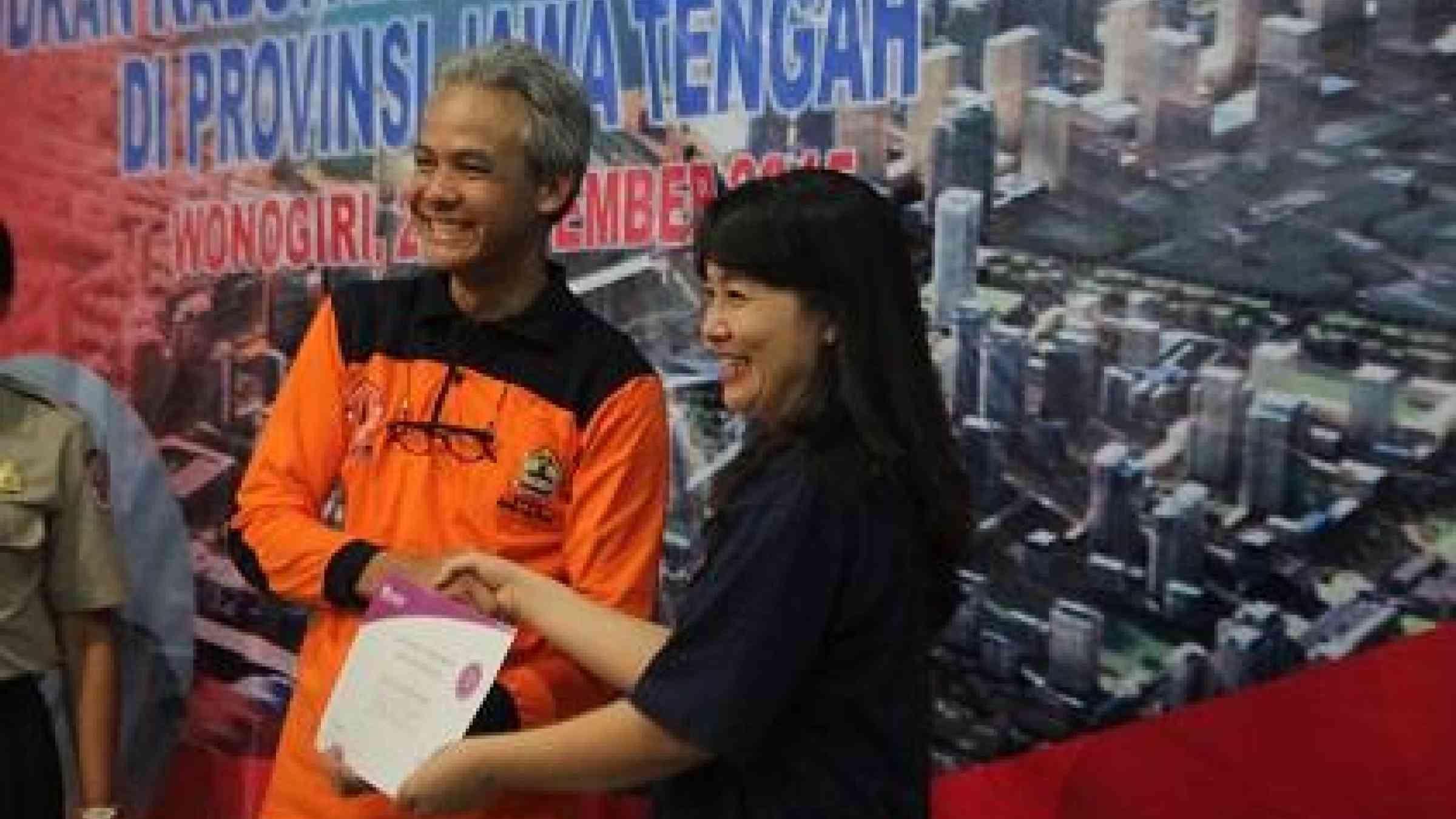 The Governor of Central Java, Mr. Ganjar Pranowo, receives a Making Cities Resilient campaign certificate from UNISDR Programme Officer Ms. Hang Thi Thanh Pham (Photo: BNPB)