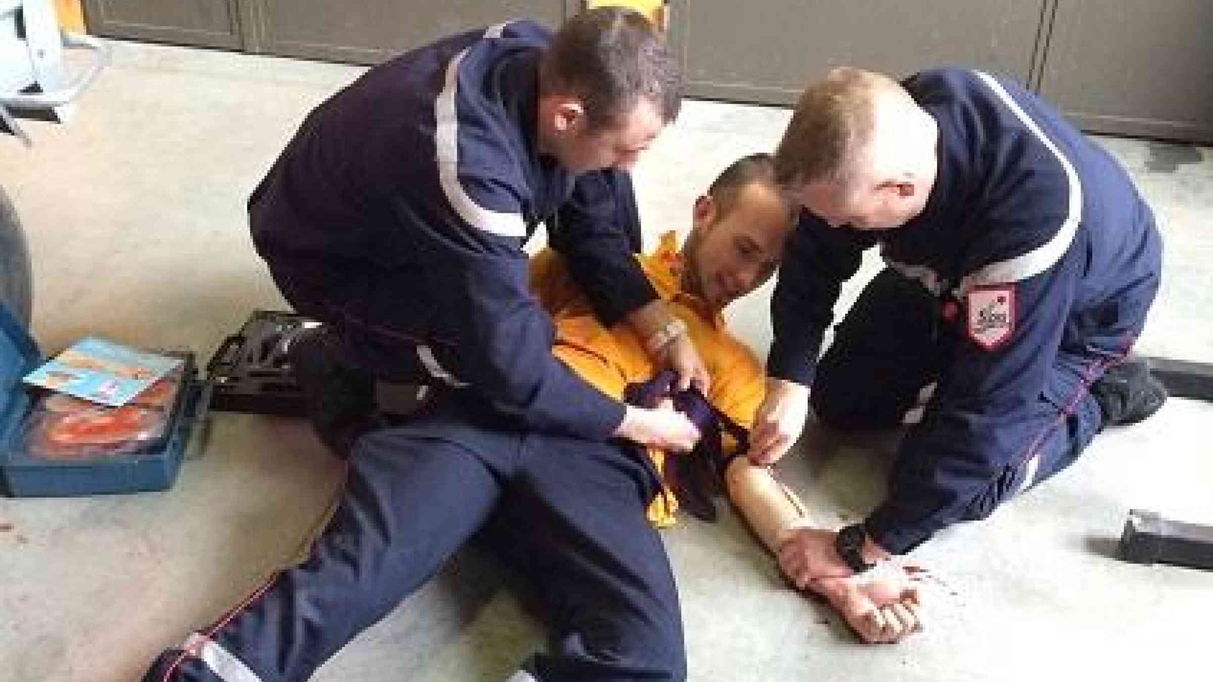 Firefighters in Thoiry show trainees how to craft a tourniquet from a necktie and a ballpoint pen, using fake blood to make the exercise more realistic (Photo: UNISDR)