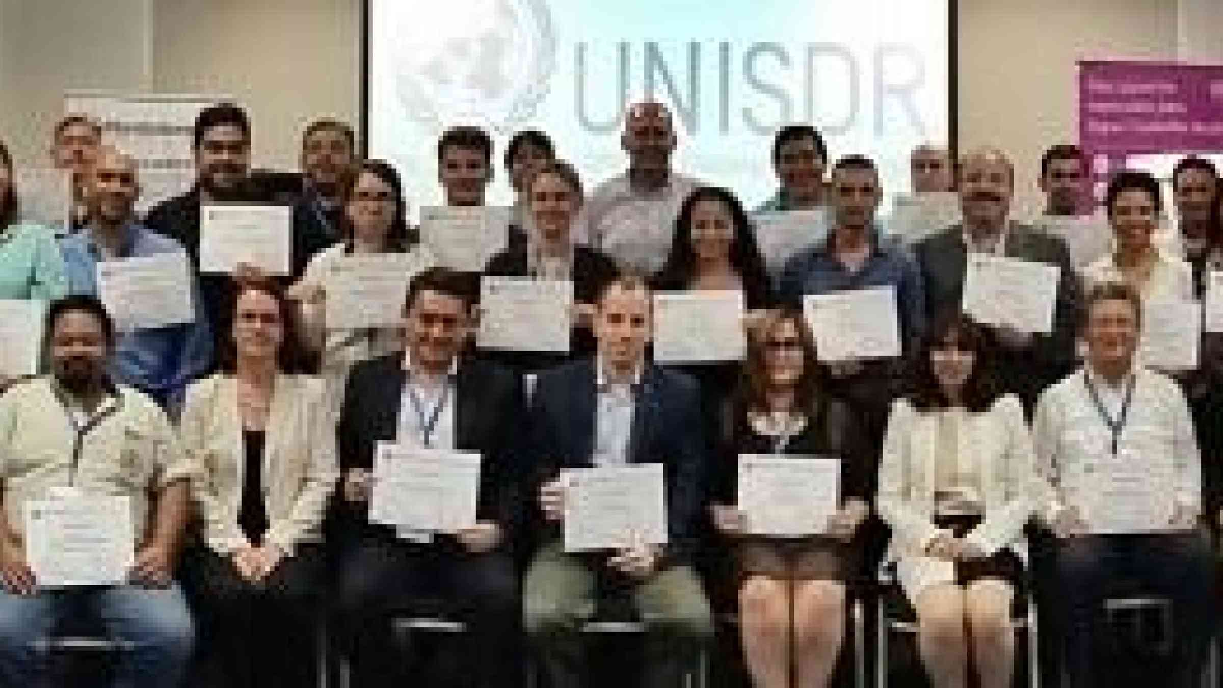 Participants display their certificates as trainers in disaster risk reduction planning (Photo: UNISDR)