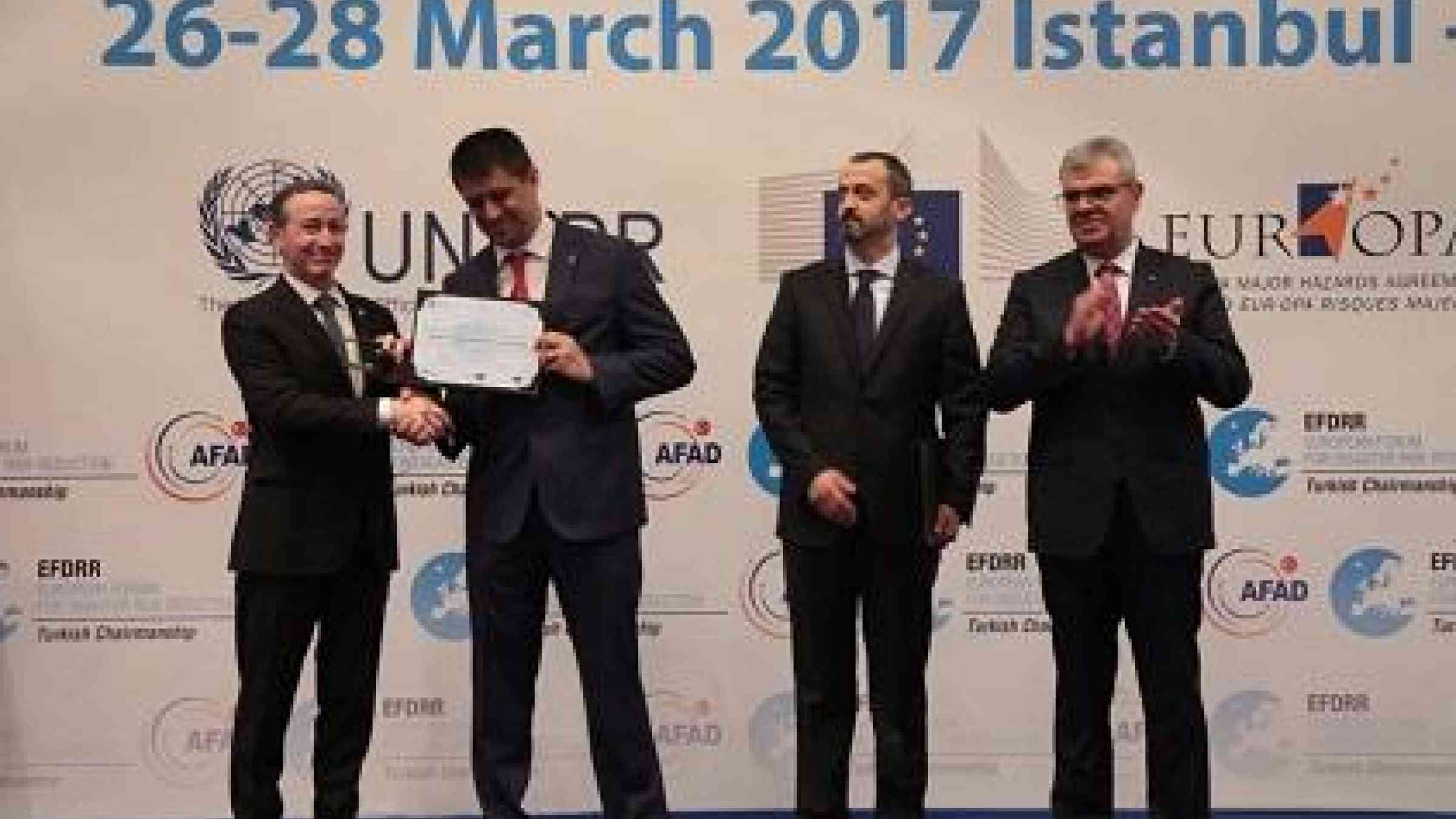Robert Glasser, Special Representative of the UN Secretary-General for Disaster Risk Reduction (left) presents the Damir Cemerin Award to Erkan Samiloglu of Turkey's Ministry of Youth and Sports, watched by Mahmut Baş of fellow laureate the Directorate of Earthquake and Ground Research, Istanbul Metropolitan Municipality (centre right), and Turkish Deputy Prime Minister Veysi Kaynak (Photo: AFAD)