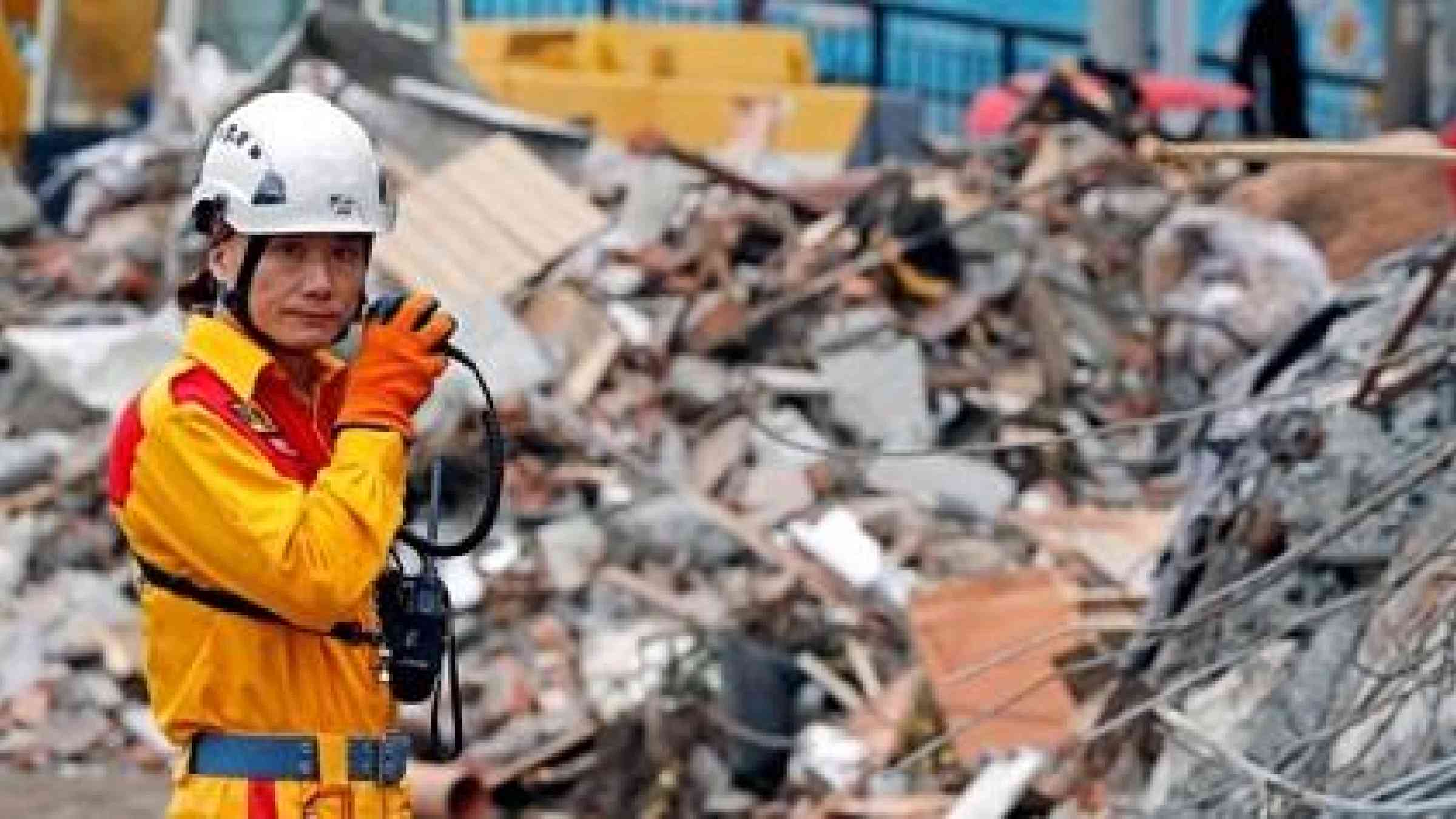 A rescuer speaks on the radio as he searches for survivors at collapsed building after an earthquake hit Hualien in Taiwan, February 8, 2018.