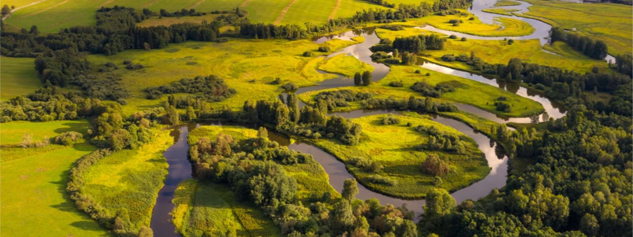 River flowing through green fields and hills.